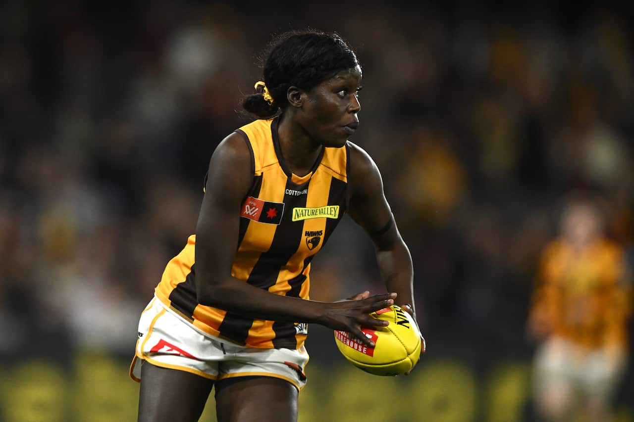 A woman holding a football in her hand during play.