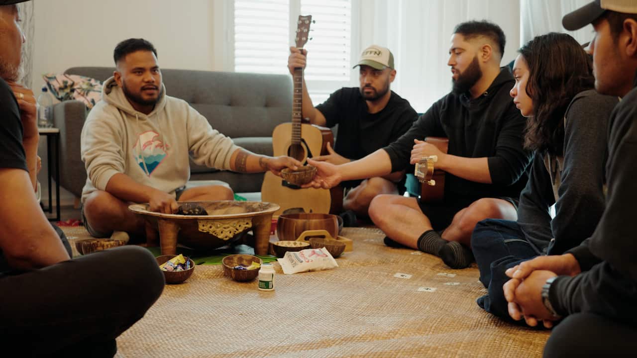 A group of people sitting in a circle drinking kava.