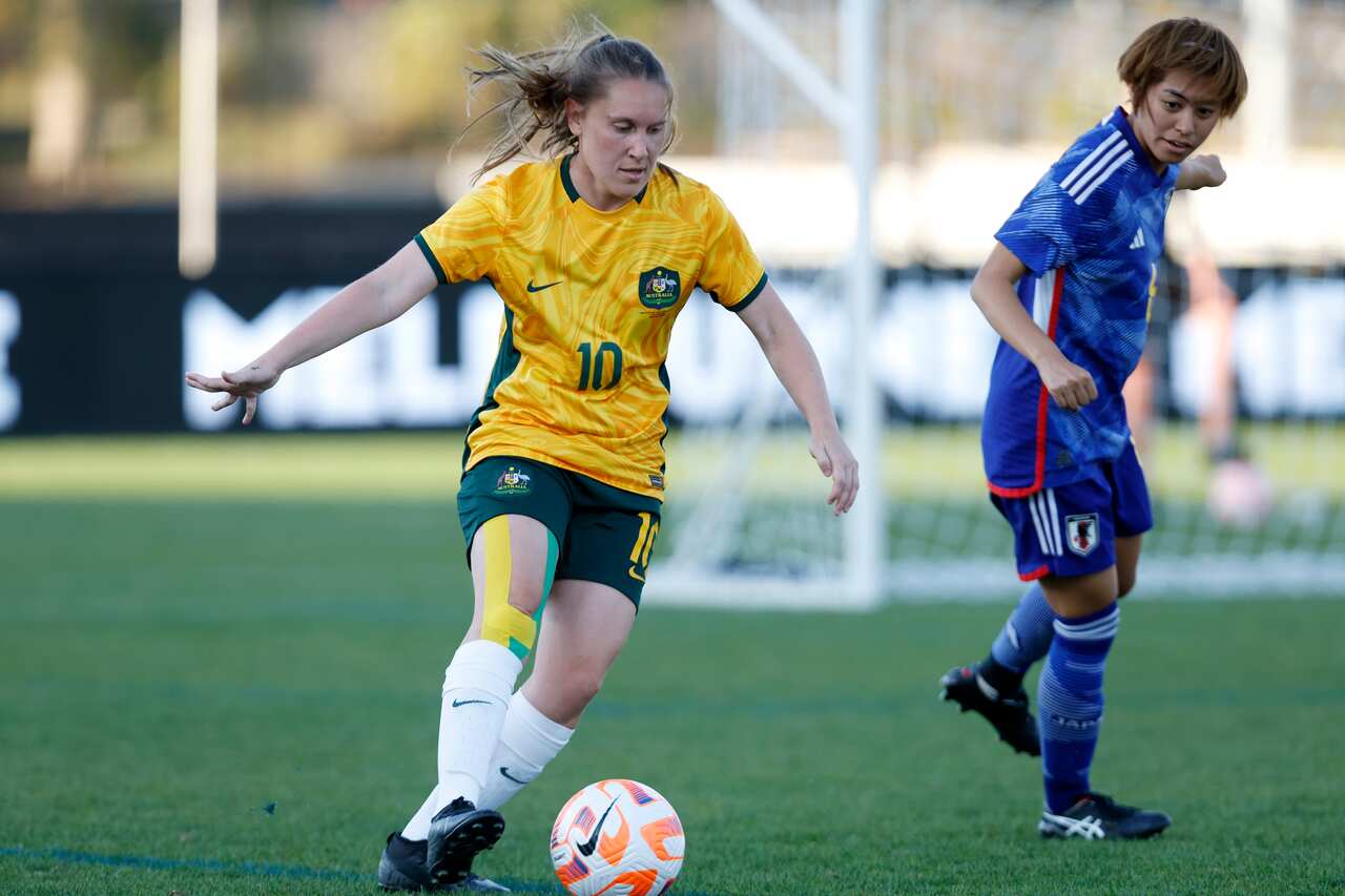 A woman runs with a football. 