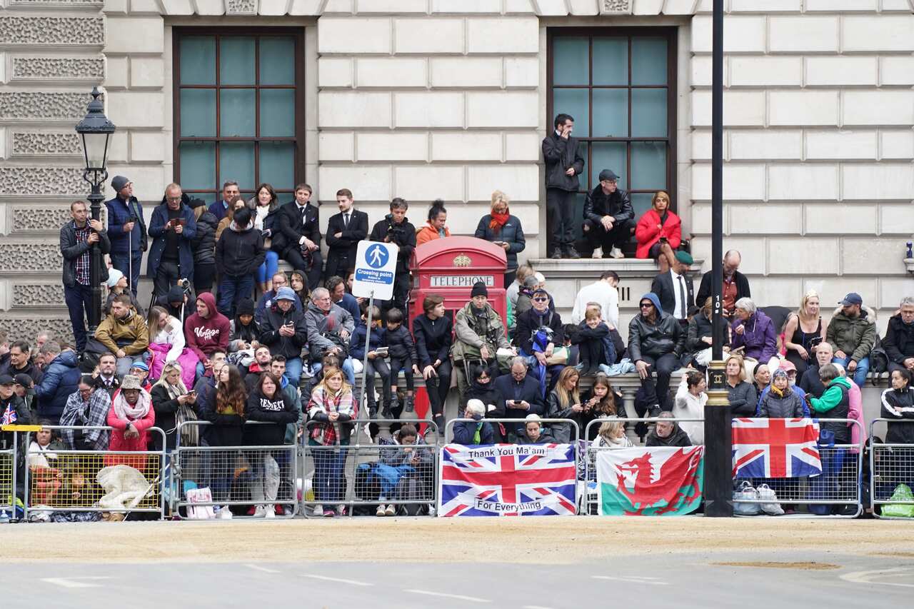 Members of the public are seen lining the streets ahead of the State Funeral of Queen Elizabeth II. 