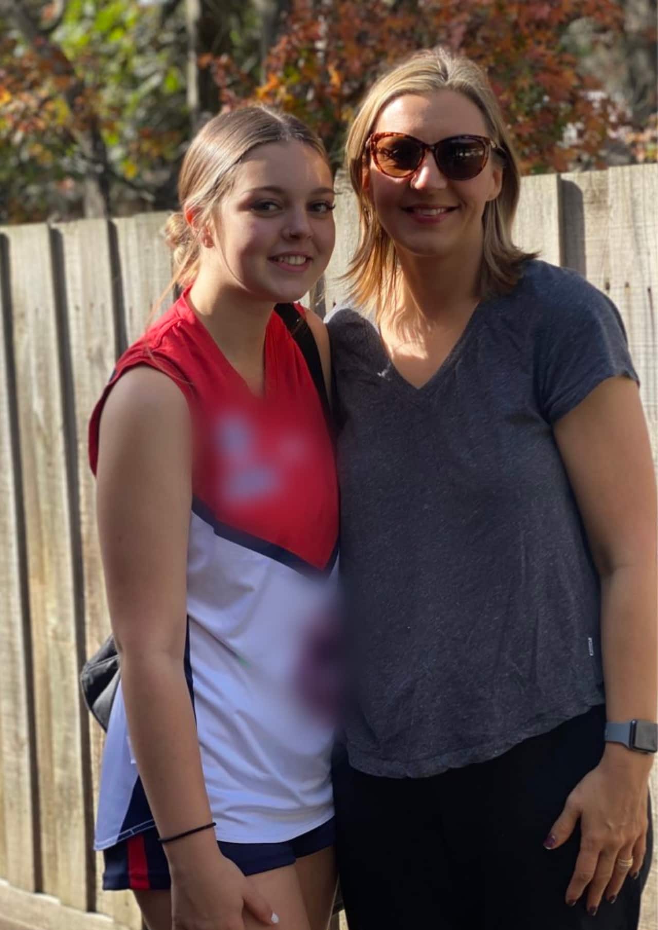 A mother and daughter standing next to each other for a photo. 