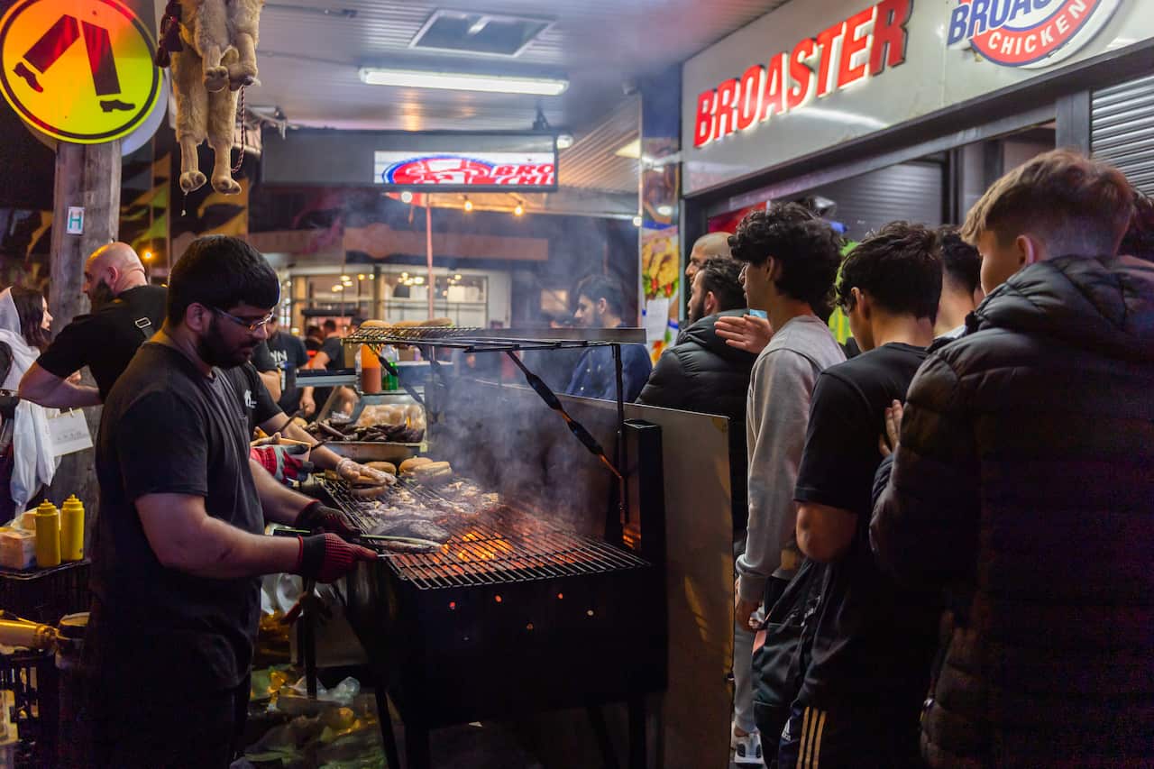 People queuing at a food stall at night