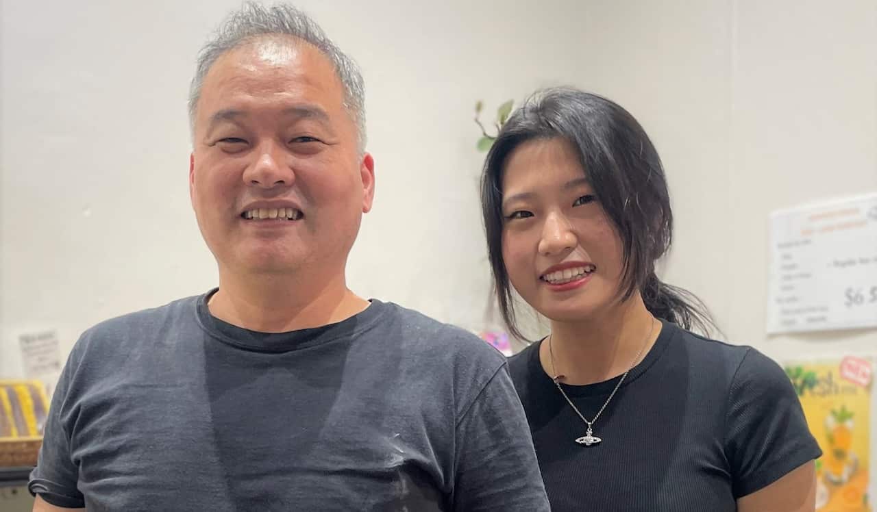 A man in a dark grey t-shirt standing next to a woman in a black t-shirt.