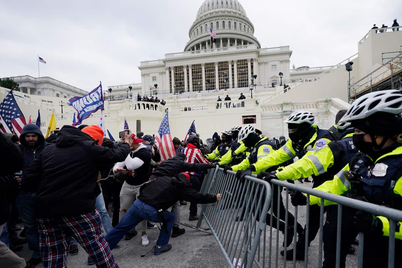 Violent protesters try to break through a police barrier at the Capitol in Washington, DC.