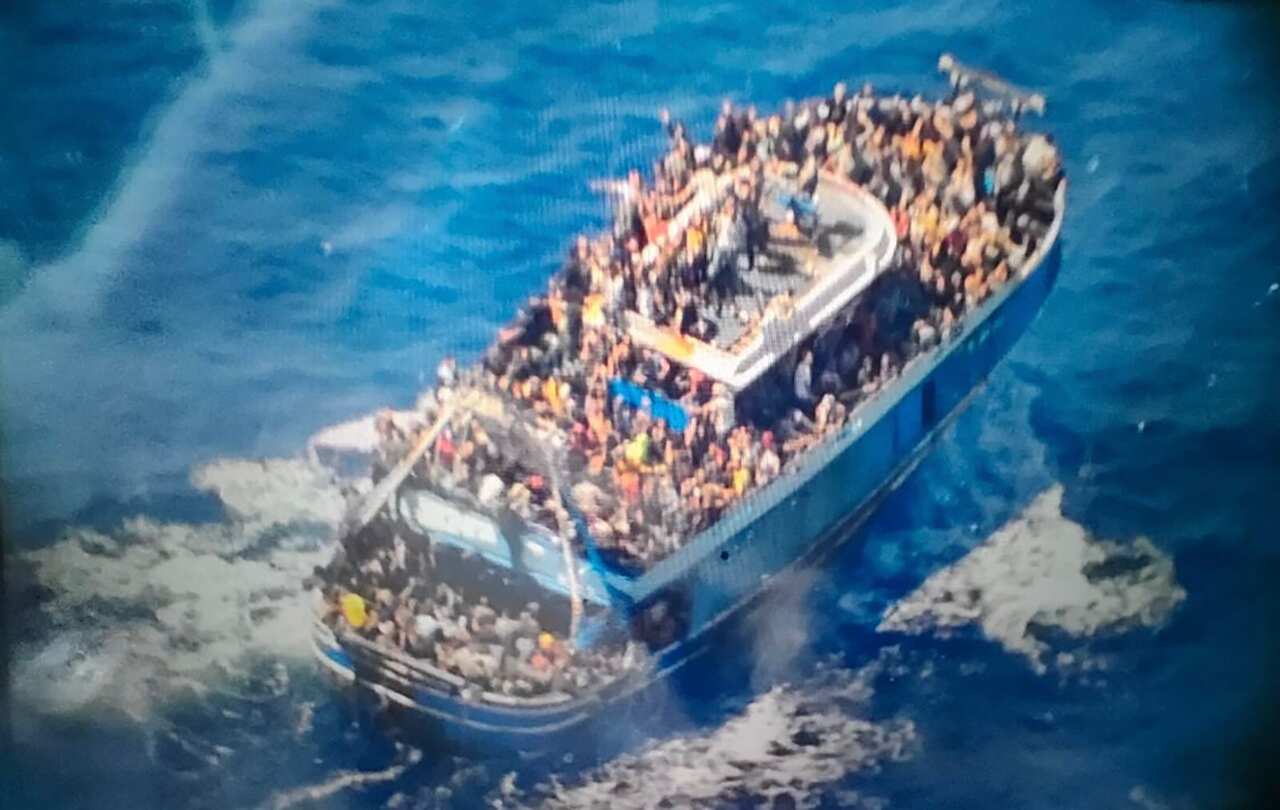 The capsized boat carrying scores of people on deck. 