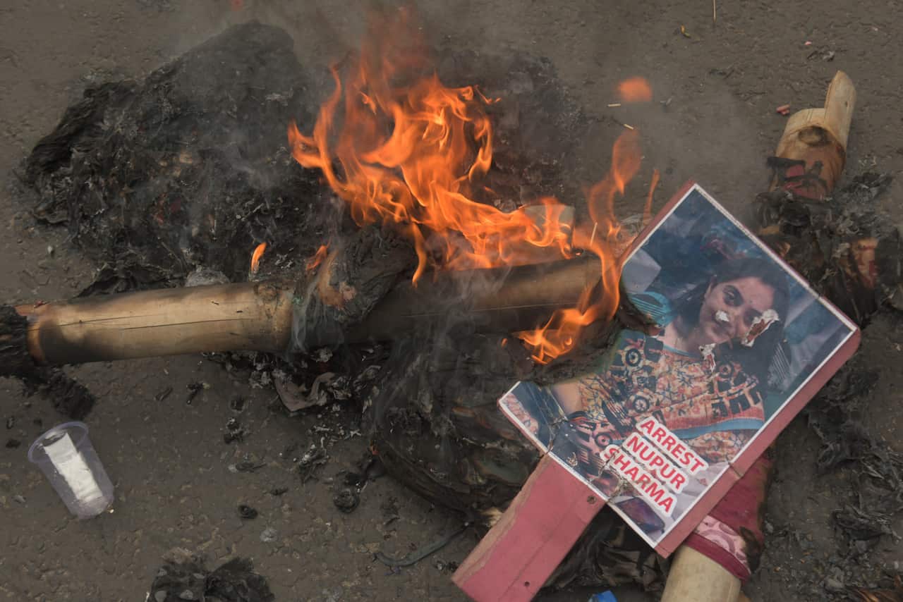 A placard with a woman's face burns on the street
