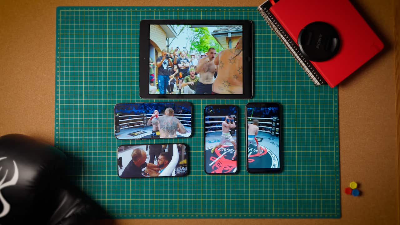 A bunch of small screens on a green mat showing bare knuckle boxing.