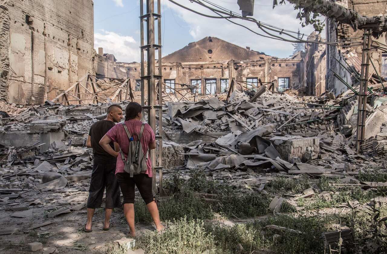 Locals look at destroyed buildings in Lysychansk after heavy fighting in the Luhansk area on 18 June 2022.