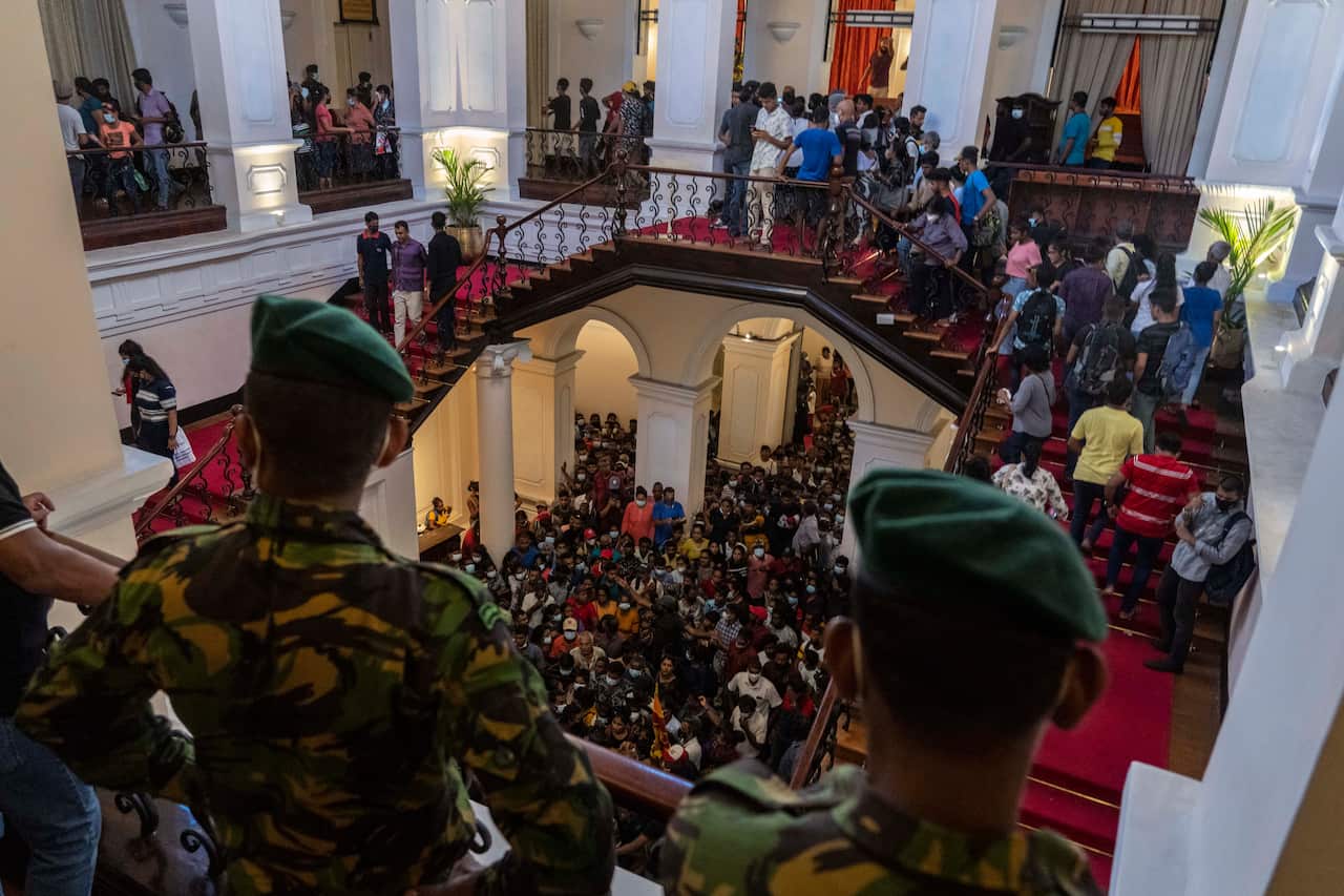 Army officers stand guard as people throng President Gotabaya Rajapaksa’s official residence for the second day after it was stormed in Colombo, Sri Lanka.