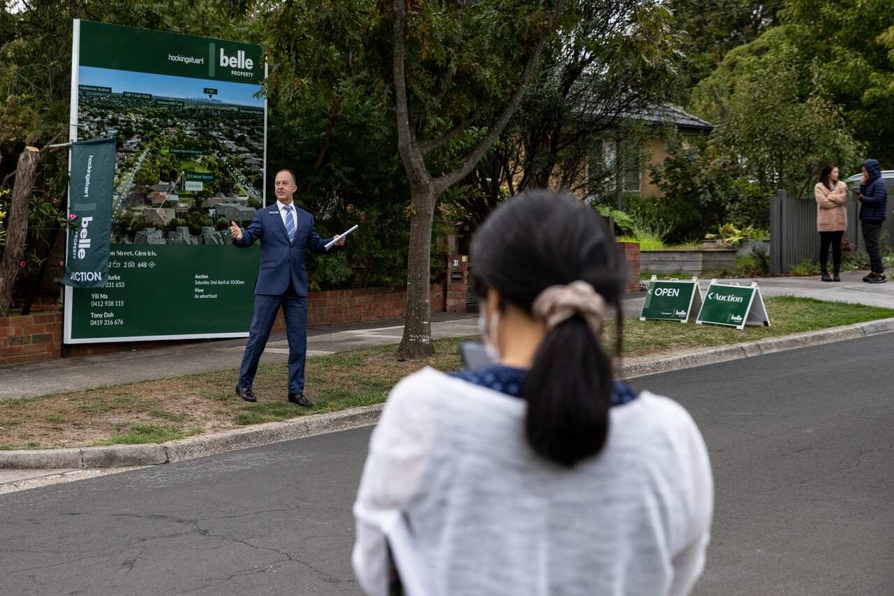 A real estate agent conducting an auction in a suburban street