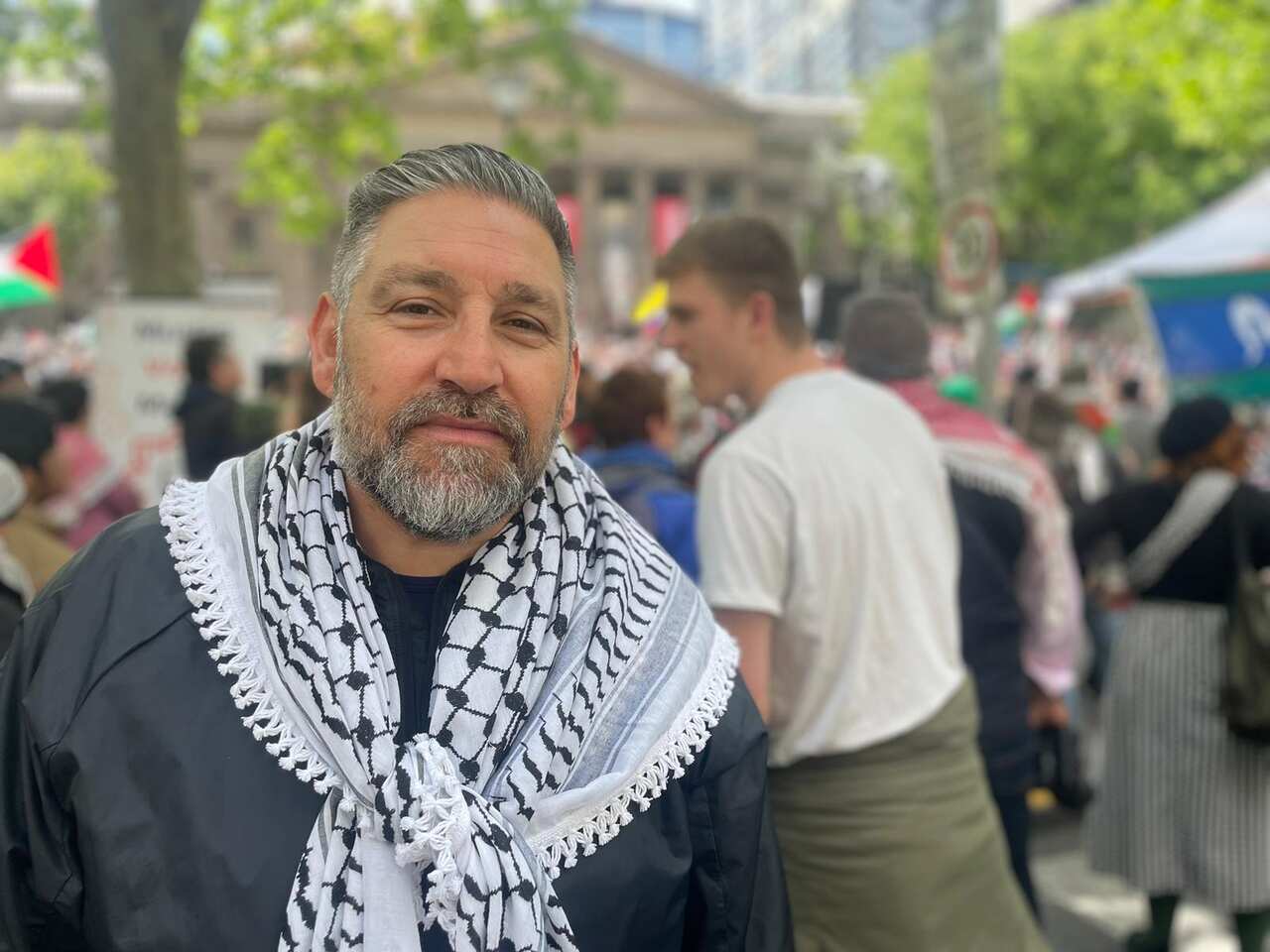 A man in a black shirt and black and white scarf