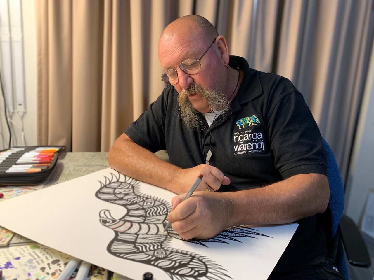 Mick Harding designing a wedge-tailed eagle symbol