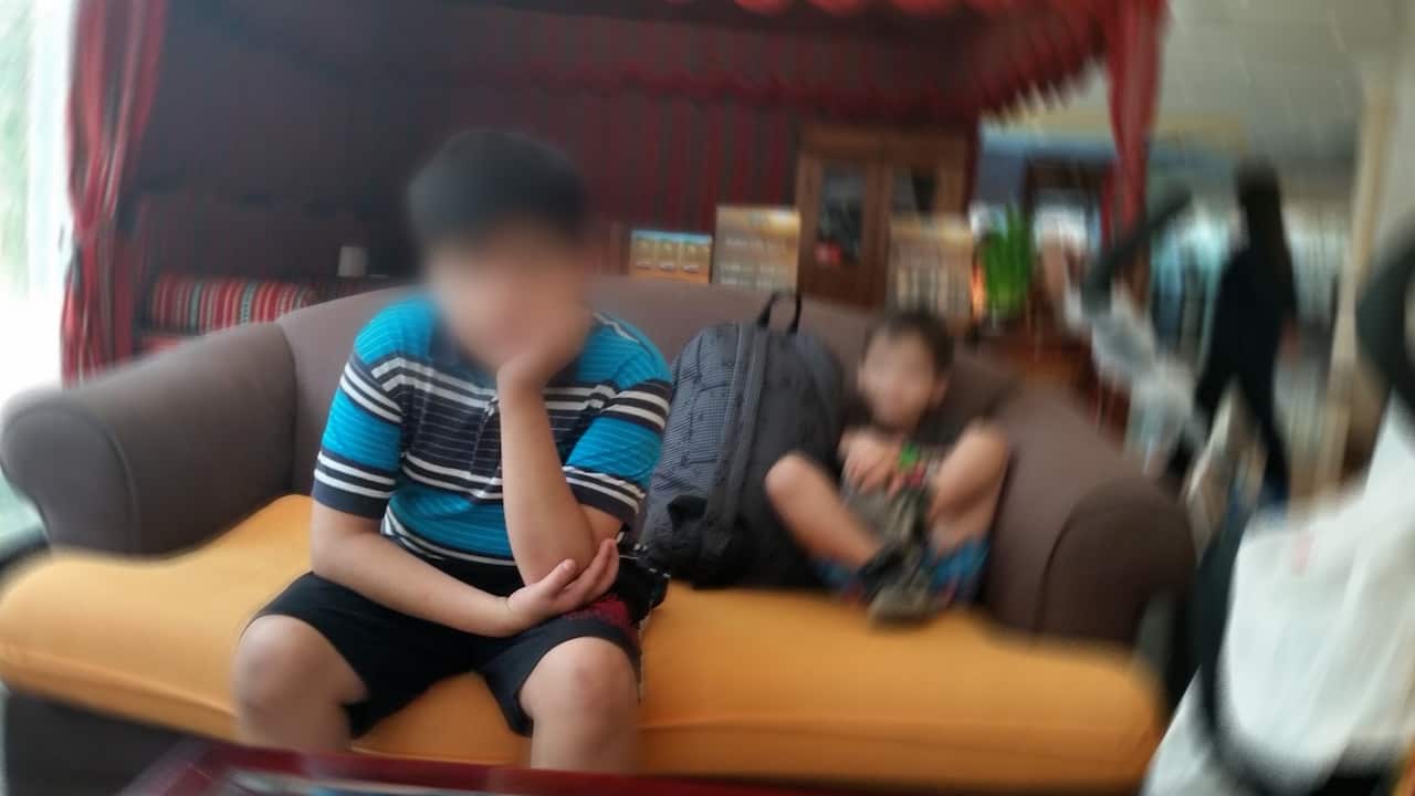 A blurred pic of a young boy sitting on a couch