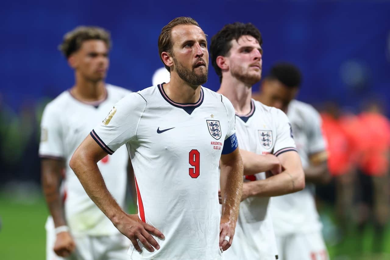 An English football player with his hands on his hips, looing sad