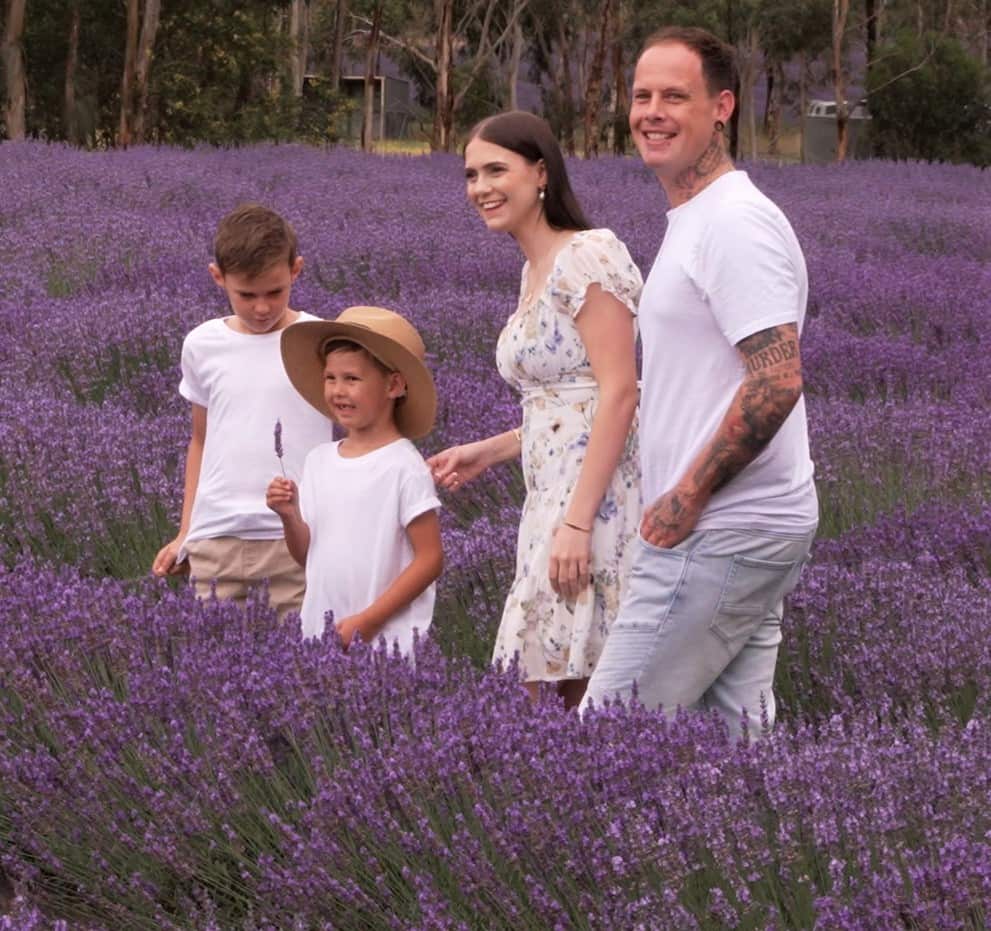 A family in white shirts standing in the lavender fields. 