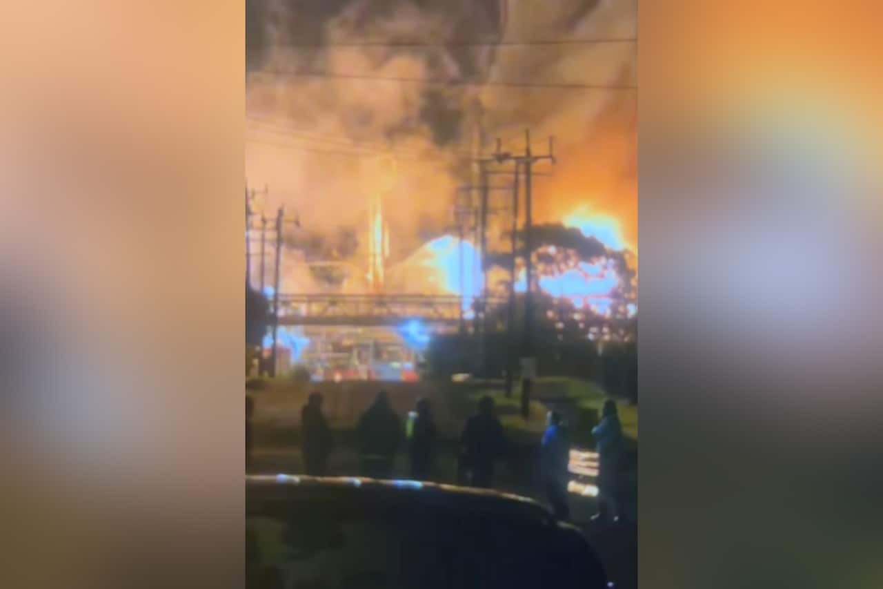 Fire and smoke billowing from an oil refinery.