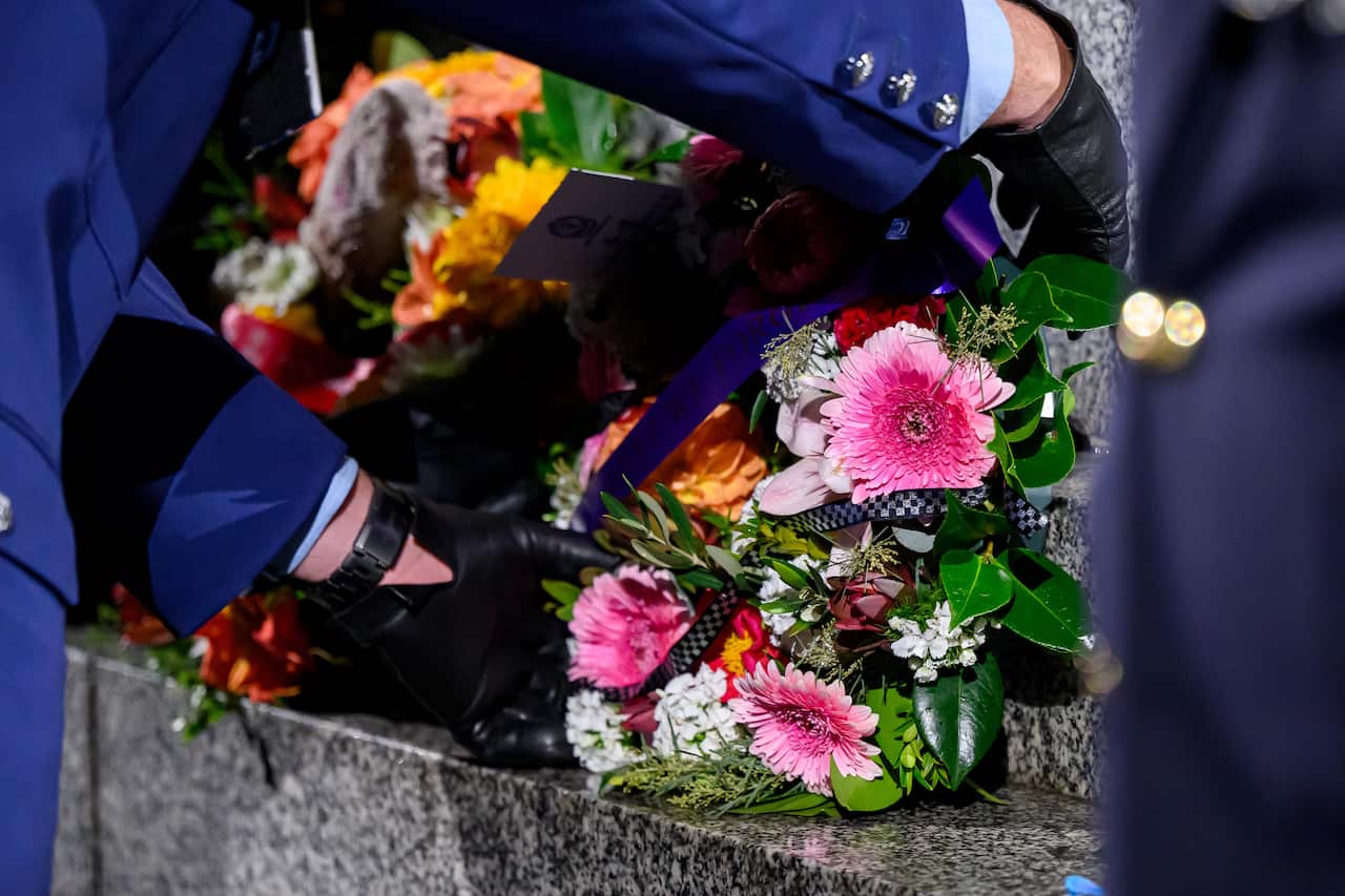 Wreaths being laid on a monument.