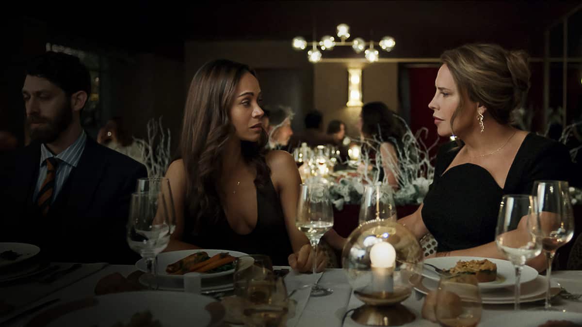 Two women staring at each other at a dinner table.