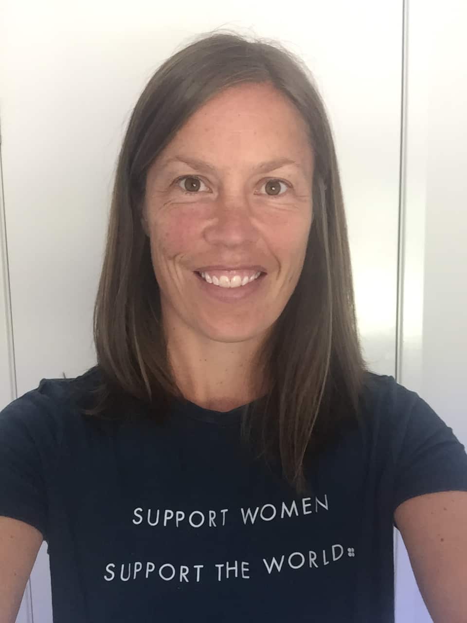 A woman with short, shoulder-length hair wearing a black T-shirt and smiling.