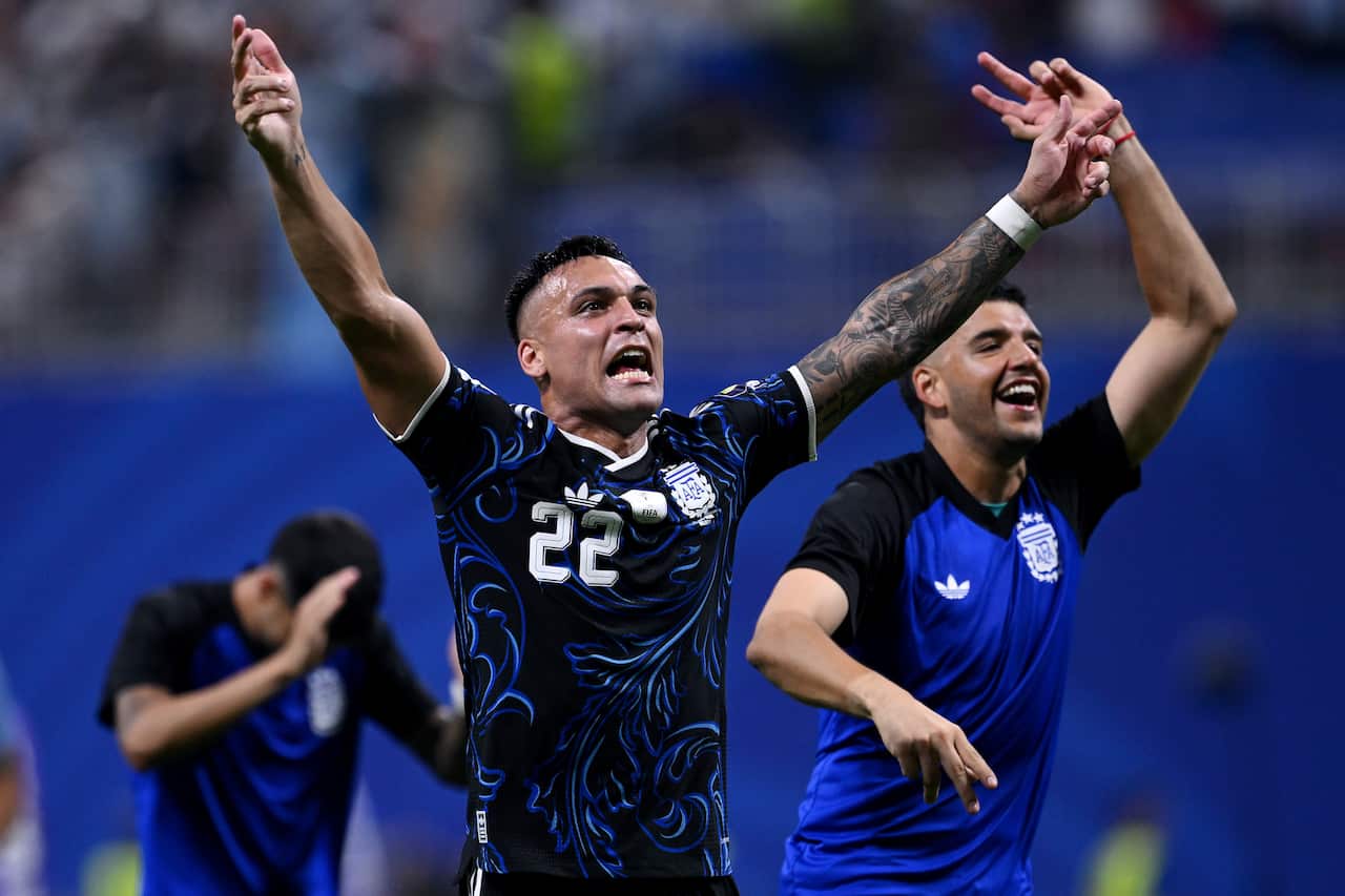 An Argentine football player with arms stretched out in celebration