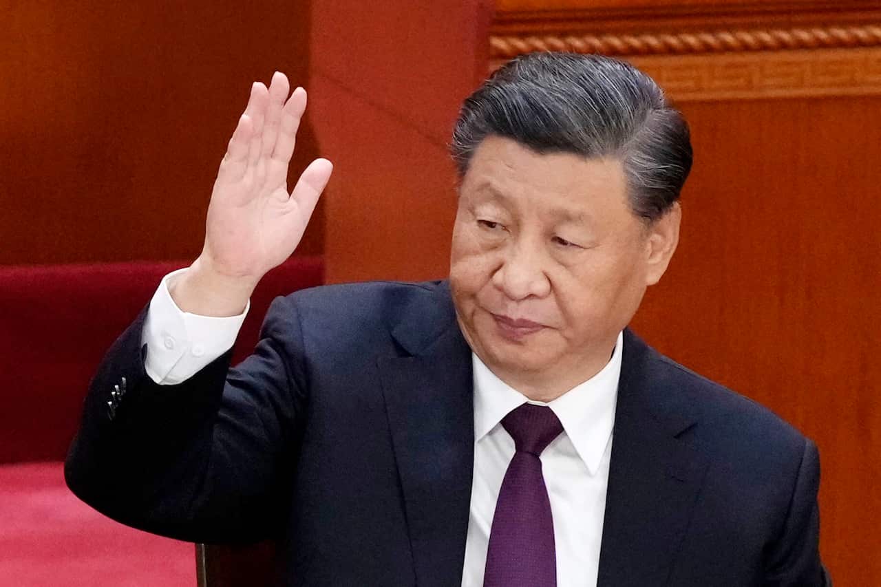 Chinese President Xi Jinping raises his hand during the closing ceremony of the 20th National Congress of the Chinese Communist Party.
