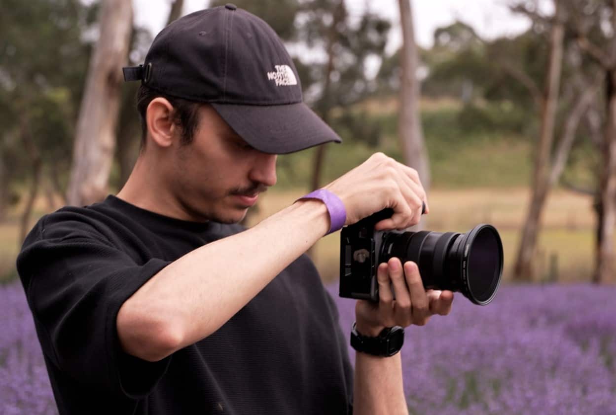 Photographer Ben Olivera, holds his camera in the lavender field.