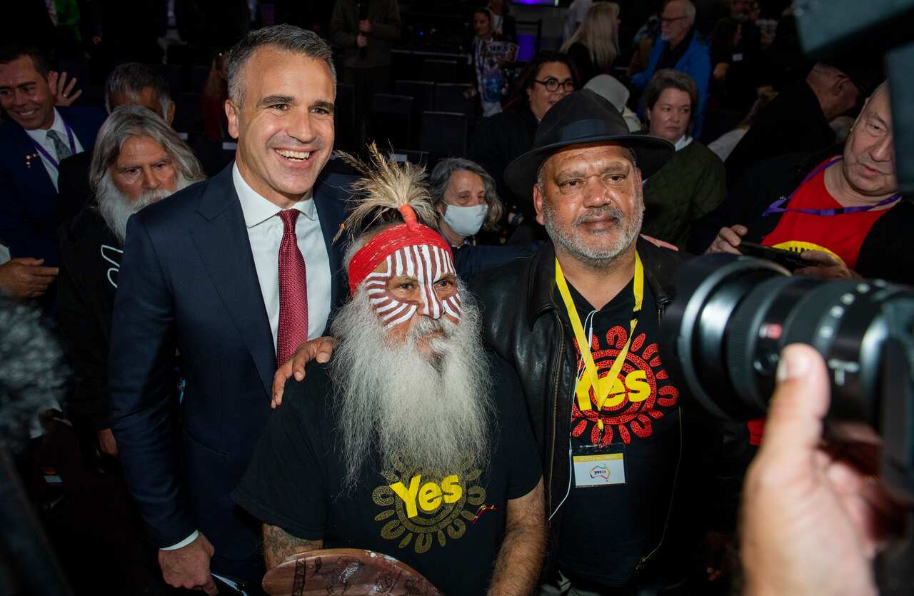 Three men smiling and posing together in front of a camera