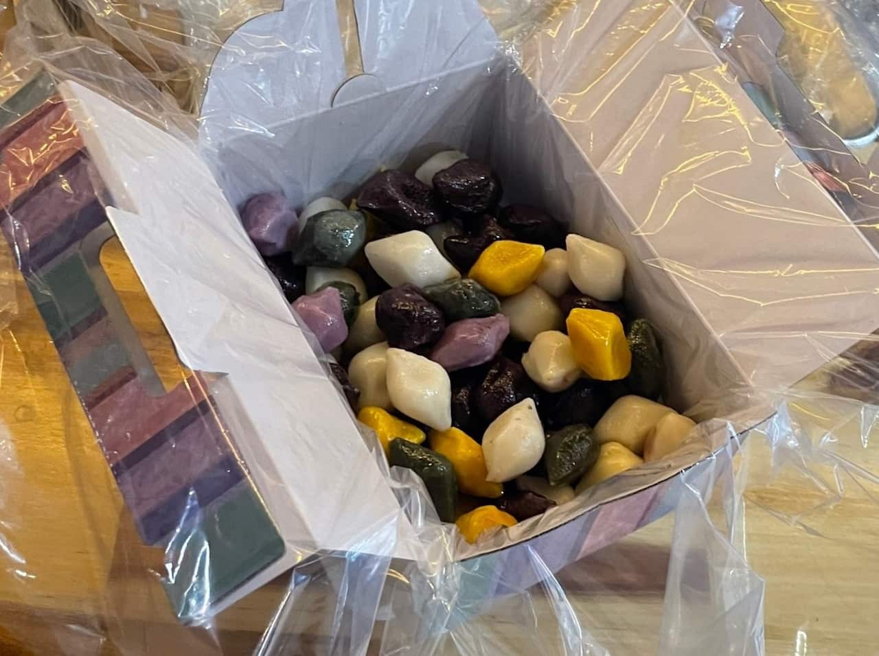 Colourful songpyeon packed in a gift box on a work bench.