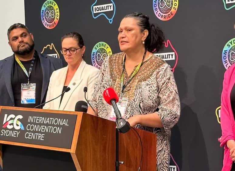 A woman in an animal print dress standing at a lectern.