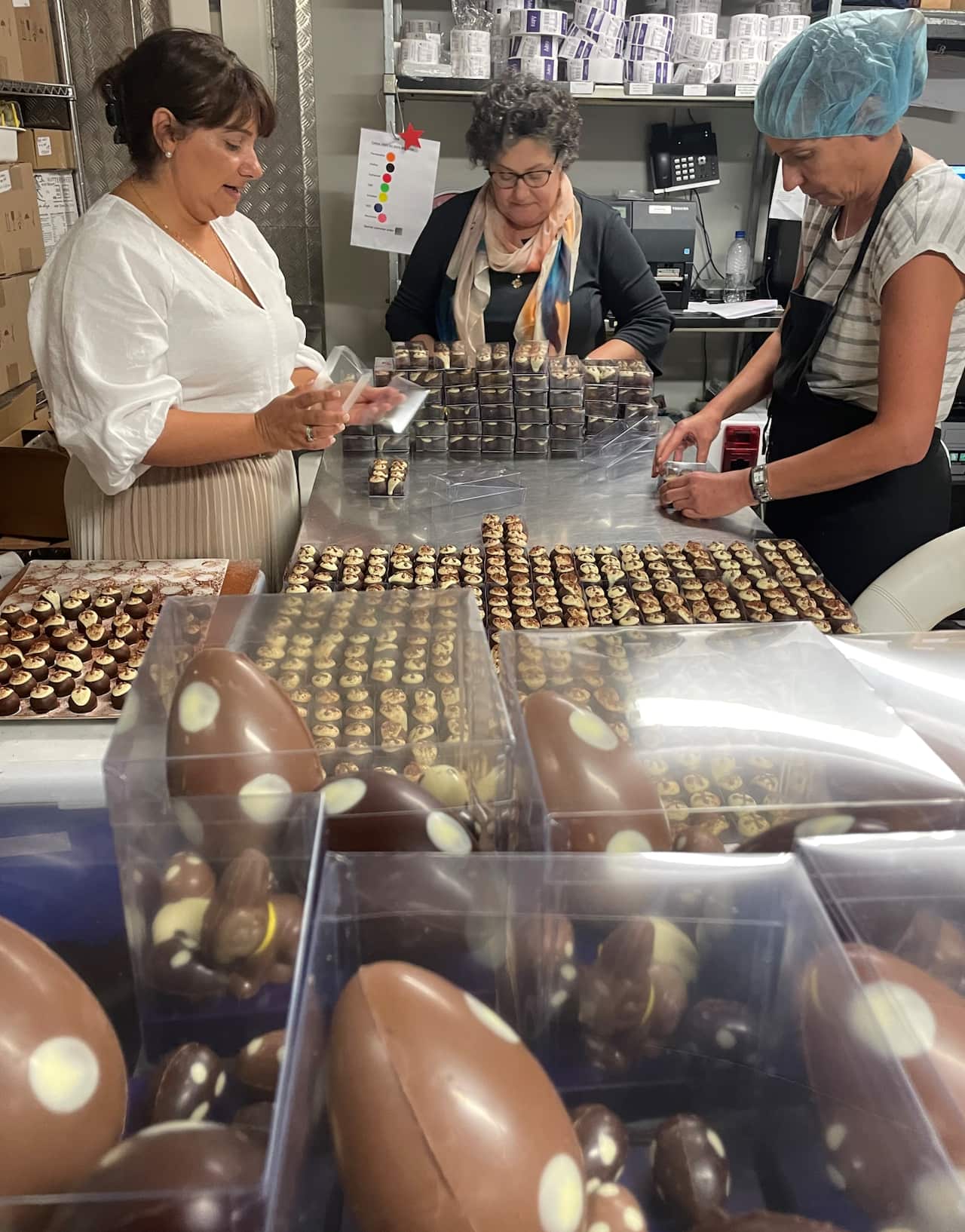 Tina Angelidis (left) and Katerina Stavropoulos packing their Easter range with a staff member at Adora's commercial kitchen.
