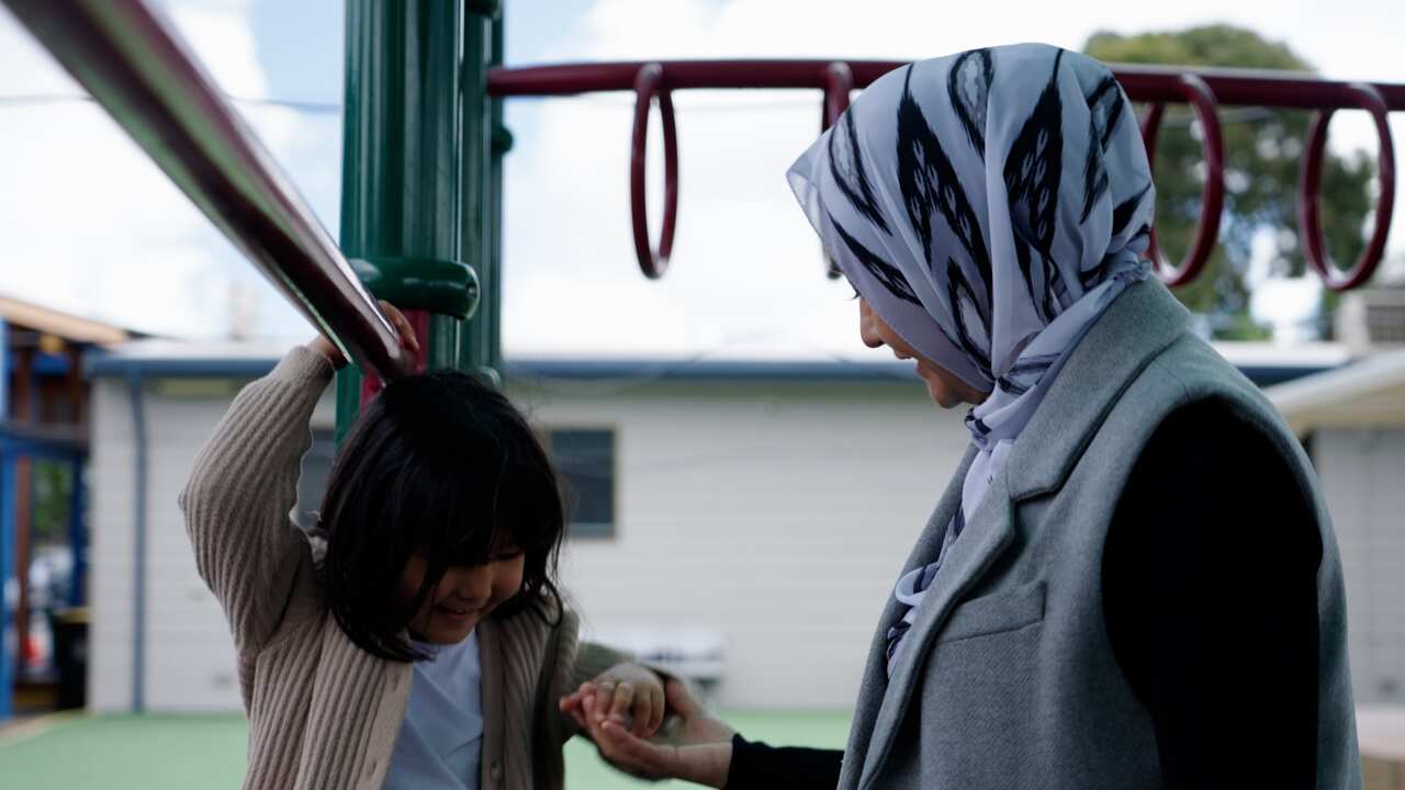 A woman with her daughter in the playground.