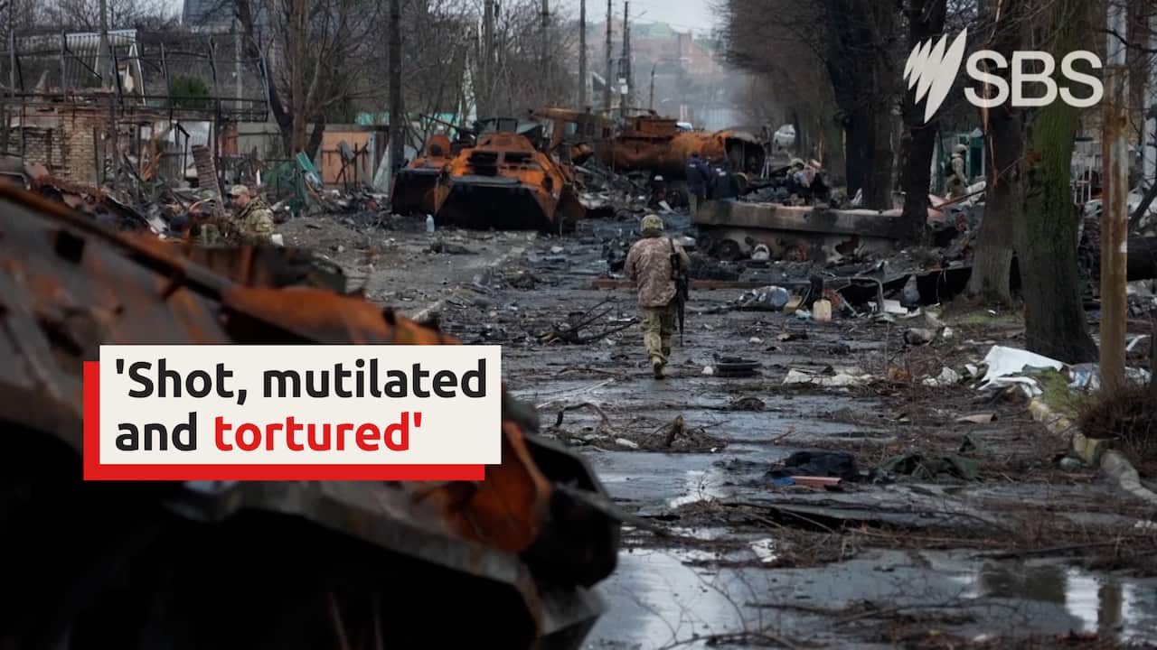 A Ukrainian soldier walks down a scorched street lined with the wreckage of homes and tanks