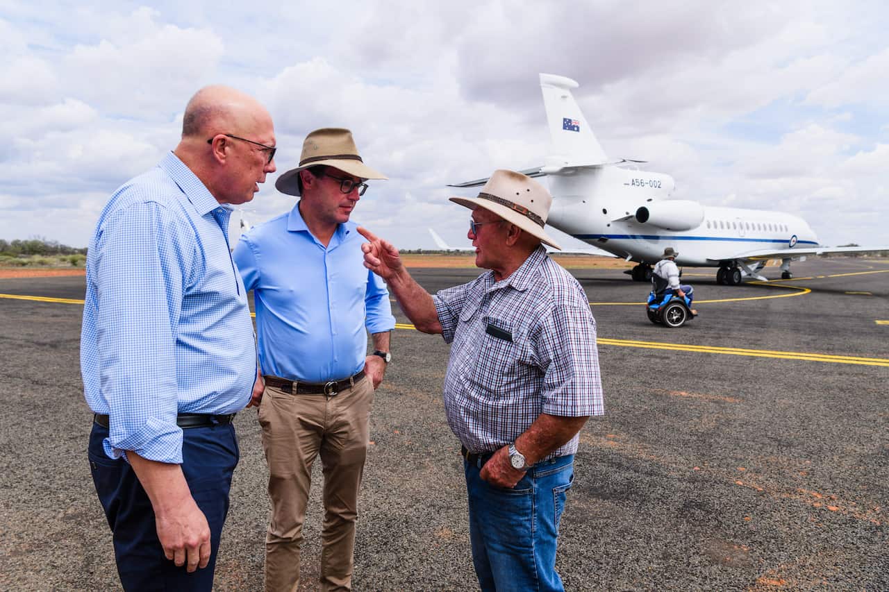 Three men, including Opposition Leader Peter Dutton stand on the tarmac of a regional airstrip