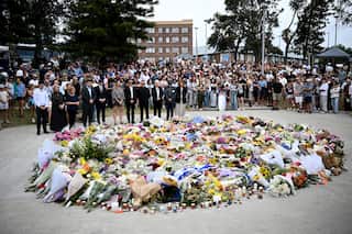 Mourners place flowers at a memorial at Bondi Beach.