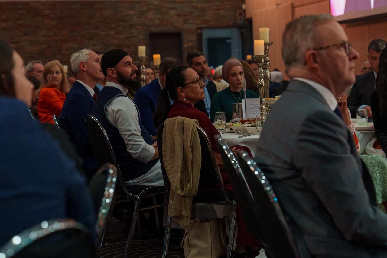 People sit on seats in a function centre. 
