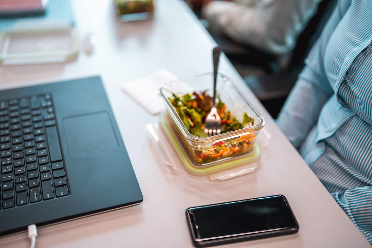 Woman Eating A Salad In Front Of A Computer At The Office