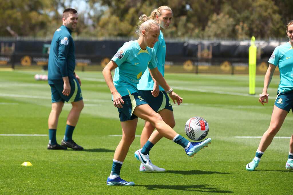 A female footballer kicking the ball at training