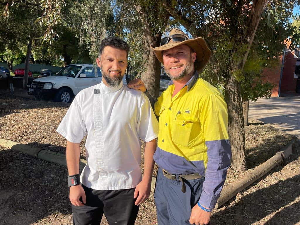 Rohullah Hussaini and his friend Mahnooz Siddiqi smiling together.