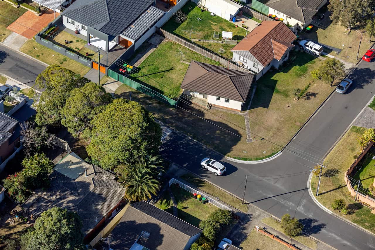 An aerial shot of houses, streets and cars showing suburban life in Australia
