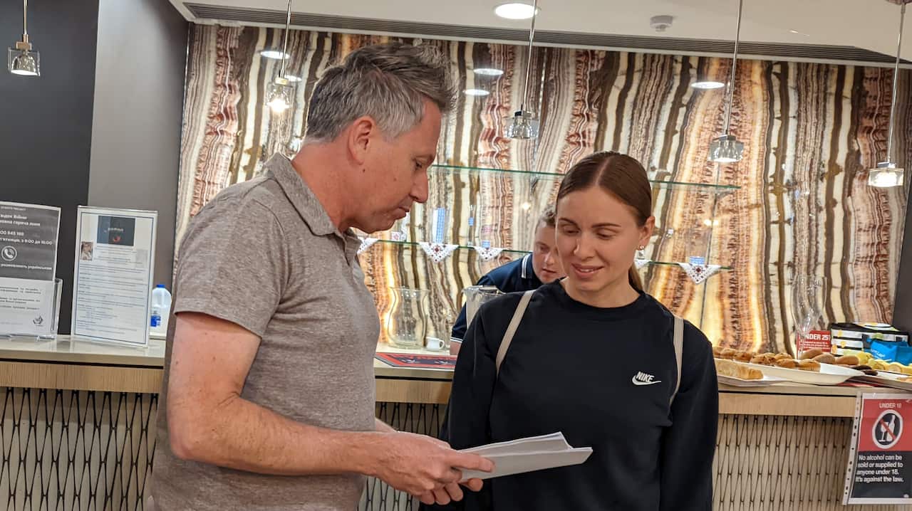 A man shows a woman a guidebook