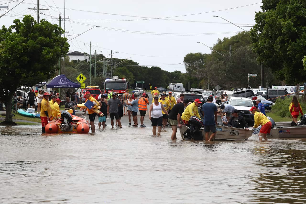Residents and rescue personnel are seen assisting one another amid flooding in Chinderah, Northern NSW, Tuesday, 1 March, 2022. 