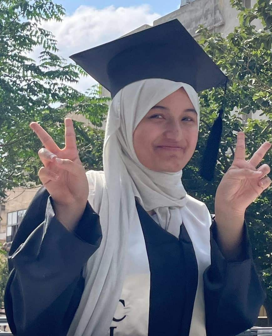 A young woman wearing a graduation cap and gown