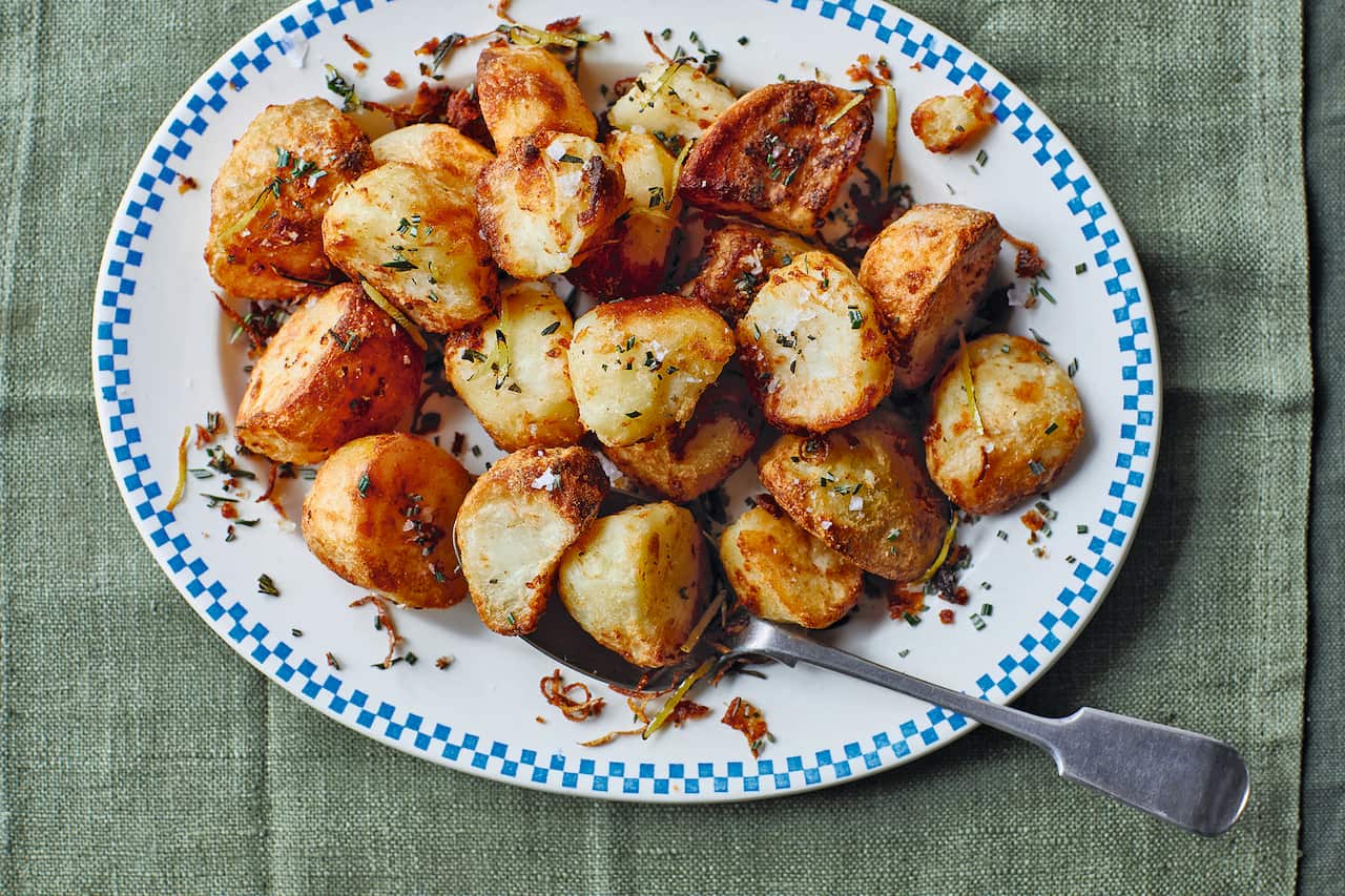 Cooked potato pieces with golden edges sit an oval platter.