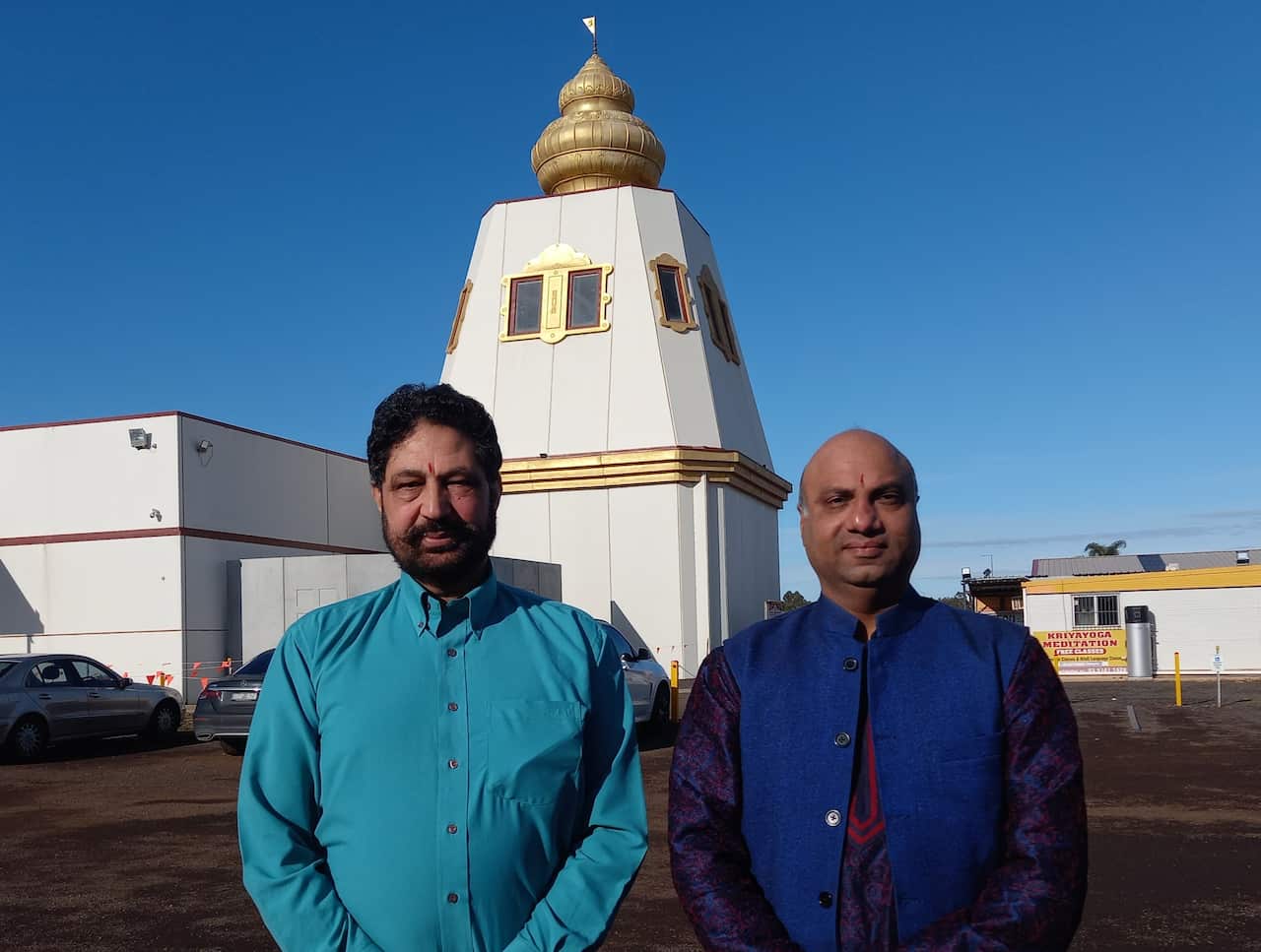 Two men standing outside a Hindu temple in Melbourne.