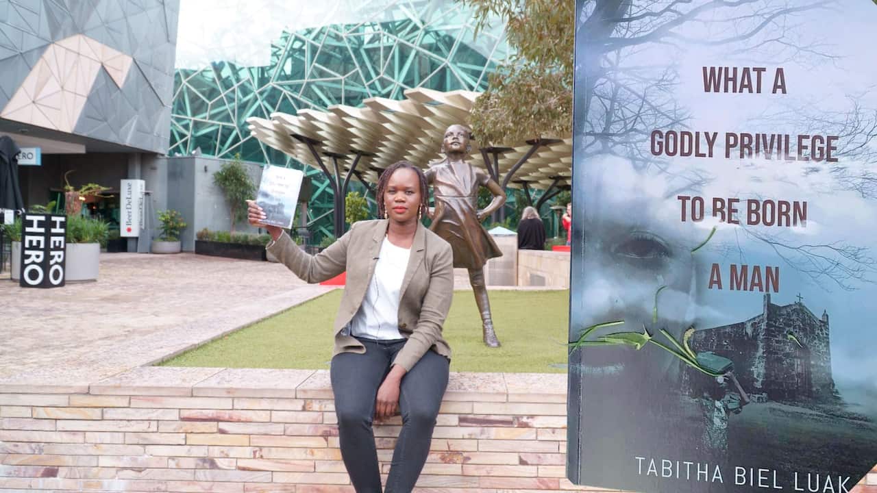 Tabitha Nyaziel sitting next to the fearless Girl Statue at Fed Square, Melbourne on 15/08/2022
