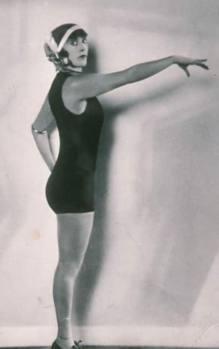 A woman in a tght-fitting swimmin costume and headpiece