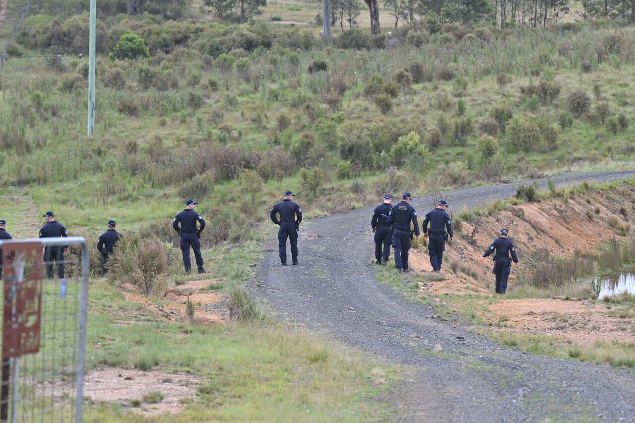 A row of policemen on a gravel road