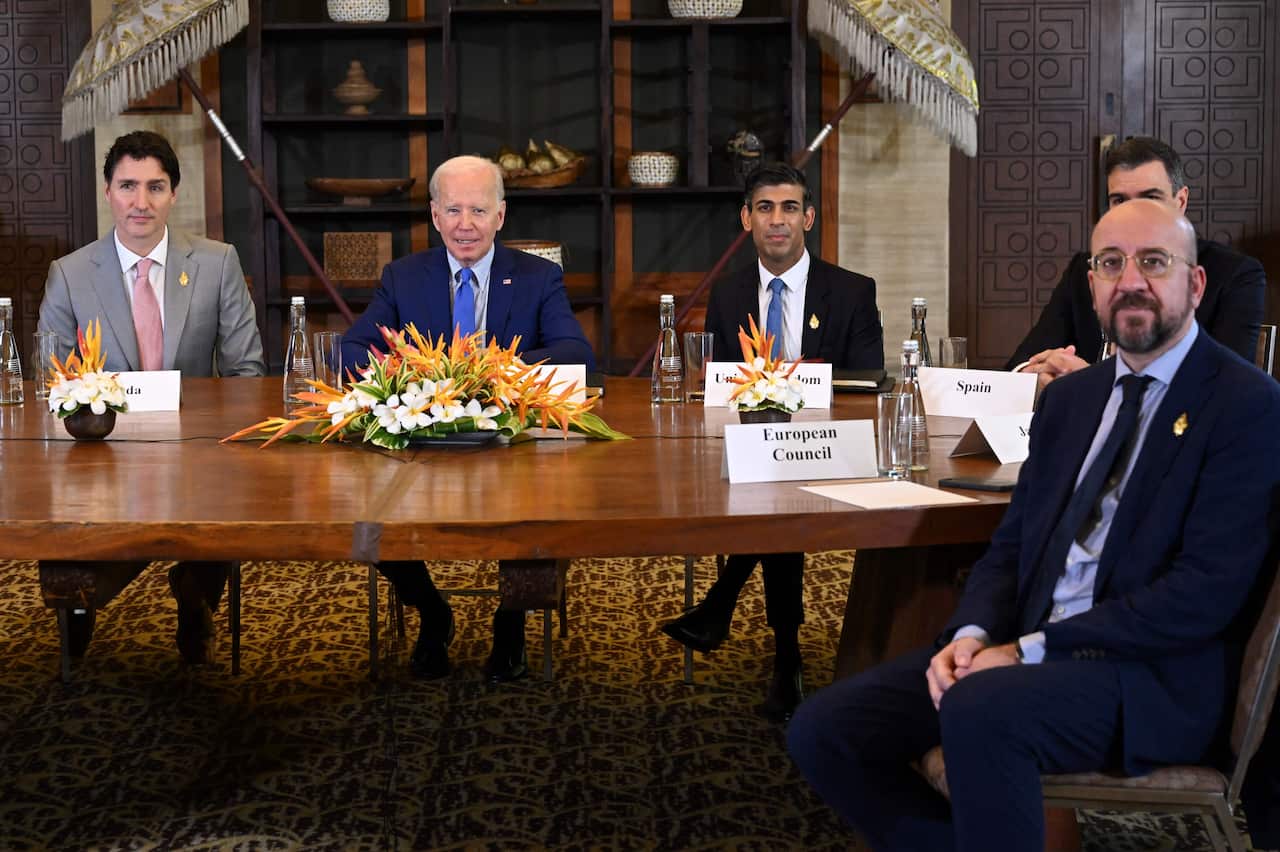Five men sitting at a table.