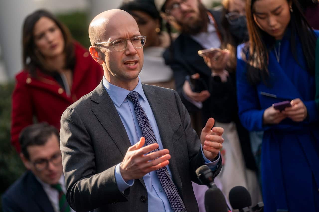 A man in a suit speaking at press conference 
