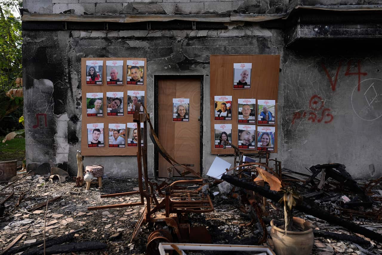 A gallery of photos on the wall of a bombed house.